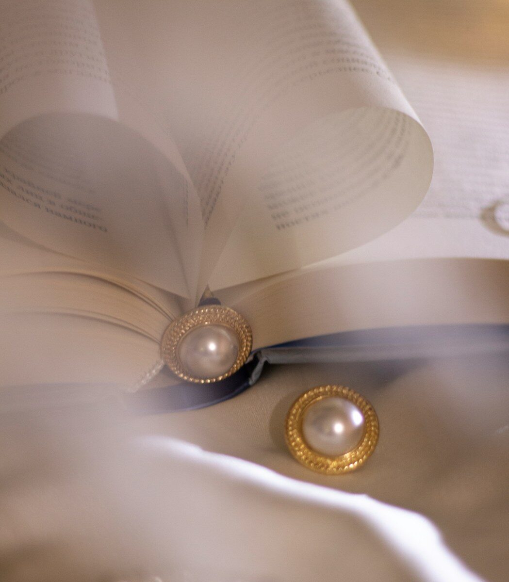 gold round analog watch on white paper